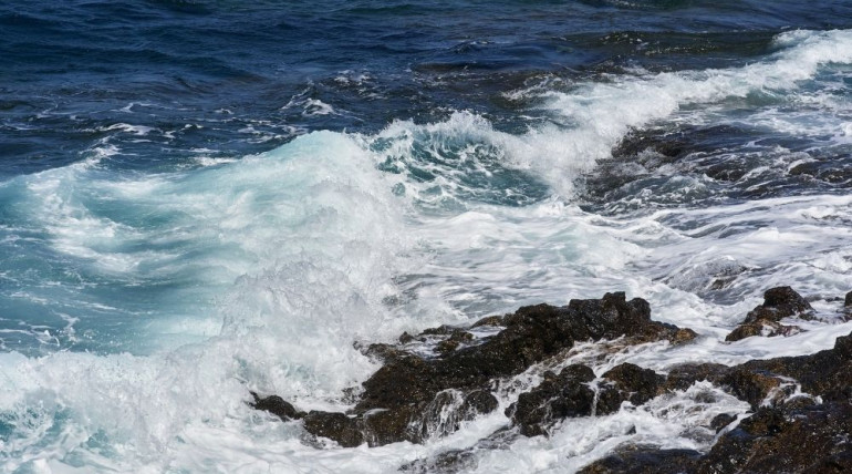 Gentle waves meeting the shoreline, illustrating movement and stillness together—symbolizing freedom found within our experiences, not apart from them.