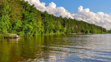Calm lake reflecting sky and trees, symbolizing quiet eyes and peace of equanimity