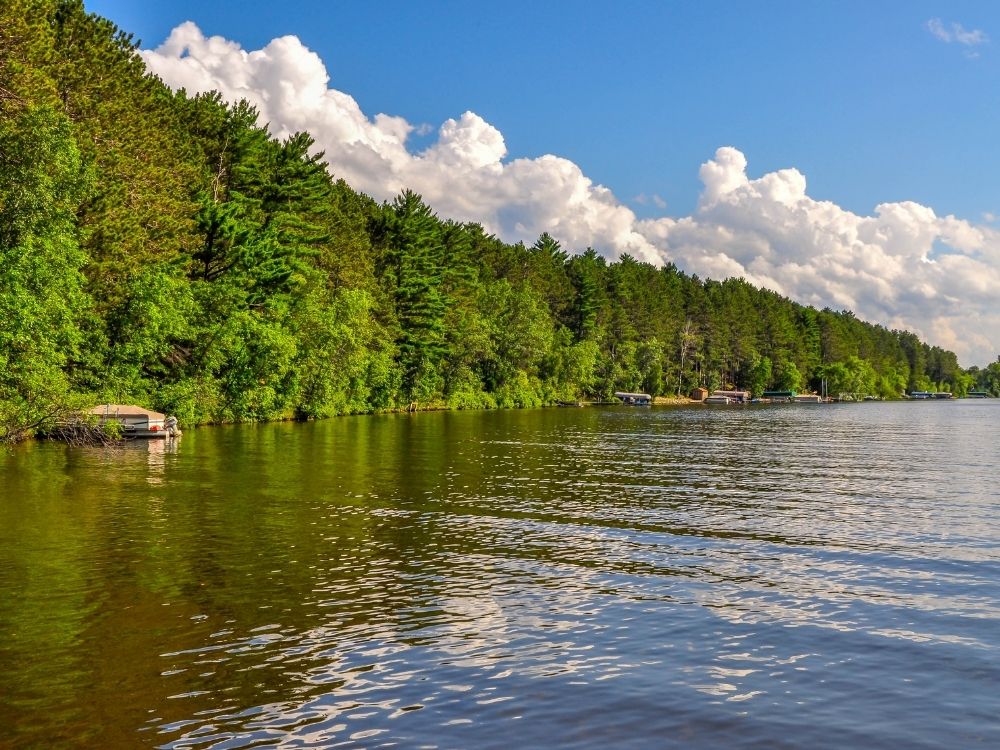 Calm lake reflecting sky and trees, symbolizing quiet eyes and peace of equanimity