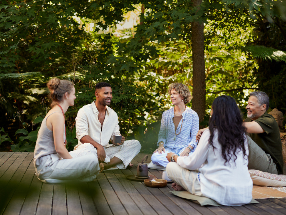 A small group sitting together in a quiet circle, reflecting shared presence and community.